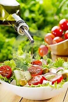 Olive oil pouring over salad