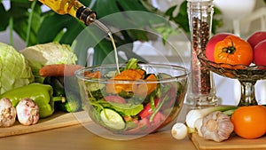 Olive oil pouring over vegetables salad. Summer organic salad in bowl. Pour Olive Oil on vegetable fresh Greek salad with tomatoes