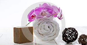 Olive oil soap, rolled towel and orchids for healthy purity