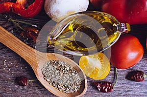 Olive oil, tomatoes and herbs on wooden table