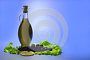 Olive oil in a transparent bottle, olives black with a lemon and