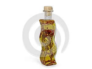 Olive oil in wavy glass bottle with rosemary twing and herbs inside isolated on white background