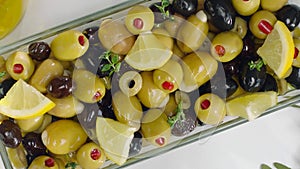 Olive salad with green and black olives and lemon, top view, zooming out