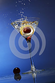 Olive splashing into a glass