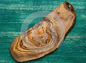 Olive wood cutting board on wooden background