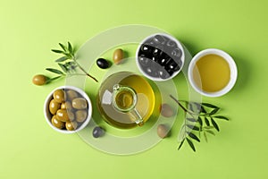 Olives, bottle and bowl with olive oil on background, top view
