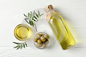 Olives, bottle and bowl with olive oil on background, top view