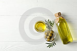 Olives, bottle and bowl with olive oil on background, top view