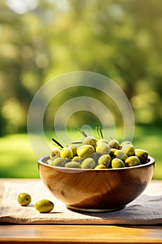 Olives in a bowl against the backdrop of the garden. Selective focus.