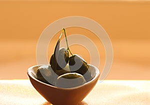 Olives in bowl of orange background