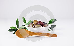 Olives in a bowl and wooden spoon