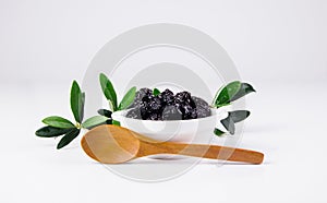 Olives in a bowl and wooden spoon.