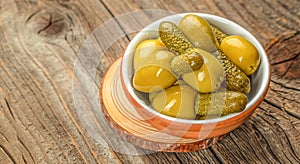 Olives with cornichons on a wooden board. Concept healthy and balanced eating. place for text, top view