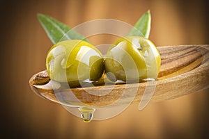 Olives with drop oil on wood spoon