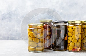 Olives in a glass jar on wooden background. pitted olives in jar