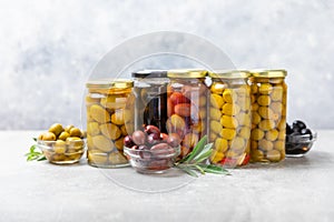 Olives in a glass jar on wooden background. pitted olives in jar