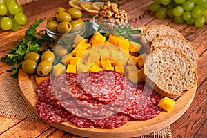 Olives, herbs, walnuts, sliced smoked sausage, cheese, bread, green grapes and lemon