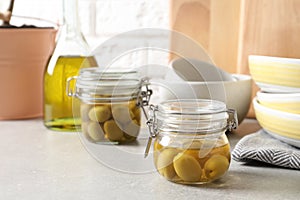 Olives in oil and dishware on table