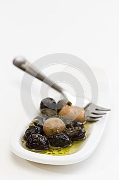 Olives, oil and spice on white plate