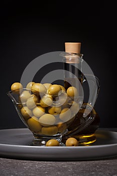 Olives and olive oil on a dark background
