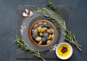 Olives and olive oil on dark stone