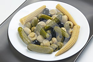 Olives, pickled cucumber, mushrooms and corn in a salad on a plate. food and vegetables. diet and weight loss