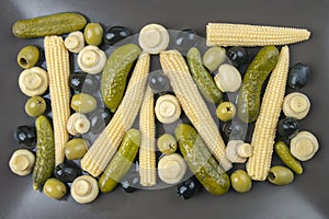 Olives, pickled cucumber, mushrooms and corn in a salad on a plate. food and vegetables. diet and weight loss