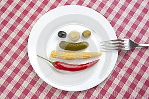 Olives, pickled cucumber, pepper, mushrooms and corn in a salad on a plate. food and vegetables. diet and weight loss