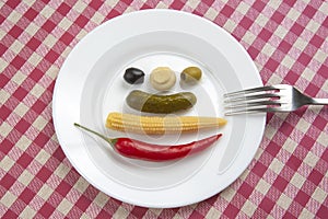 Olives, pickled cucumber, red hot peppers, mushrooms and corn in a salad on a plate. food and vegetables. diet and weight loss