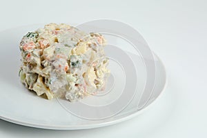 Olivier salad on white plate. vegan version of traditional russian salad Olivier from boiled vegetables