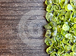 Olivine gemstone also called Peridot on old wooden background.