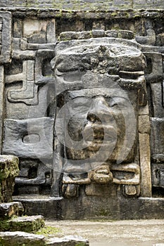 The Olmec style mask on the side of the Mayan temple of Lamanai in Belize photo