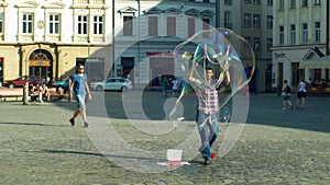 OLOMOUC, CZECH REPUBLIC, JUNE 11, 2019: Making bubbles using detergent soap and rope on chopsticks, big bubble, street