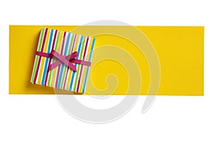 Ð¡olorful gift box on the yellow paper letter blank