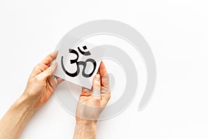 Om - Buddhist inner peace symbol - in hands on white desk top view copy space