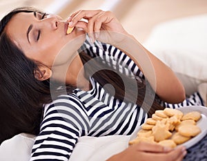 Om nom nom nom. A young woman enjoying a plate of cookies.