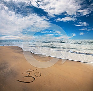 Om symbol on the beach