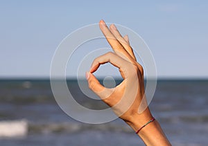 OM yoga symbol with forefinger and thumb finger touching and see