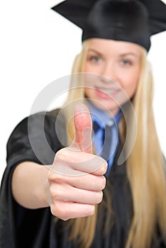 Ð¦oman in graduation gown showing thumbs up