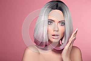 Ombre bob short hairstyle. Beautiful hair coloring woman with wow face holding hand near her cheek isolated on pink studio