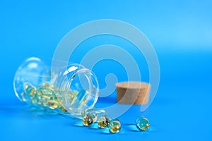 Omega 3 capsules in a glass bottle on a blue background