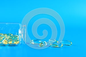 Omega 3 capsules in a glass bottle on a blue background