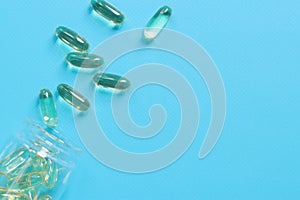 Omega 3. Capsules in a glass bottle on a blue rubberized background, top view