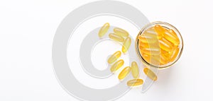 Omega 3 capsules in glass jar on white background Fish oil Yellow softgels Vitamin D, E, A supplement Banner