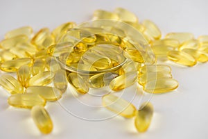 Omega 3 capsules lying in the lid on a white background. Scattered around.