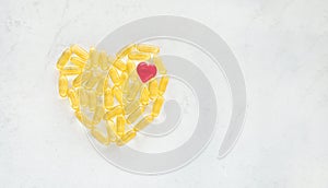 Omega 3 capsules pills heart shape on a marble background. Health care concept.