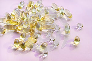 Omega 3 fish oil gel capsules, vitamin E. Close-up medicine yellow transparent pills, omega 3 fish oil capsules, vitamin