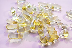 Omega 3 fish oil gel capsules, vitamin E. Close-up medicine yellow transparent pills, omega 3 fish oil capsules, vitamin