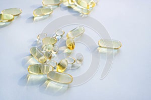 Omega 3 fish oil gel capsules, vitamin E. Close-up medicine yellow transparent pills, omega 3 fish oil capsules, vitamin