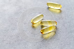 Omega-3 fish oil supplements on gray stone background